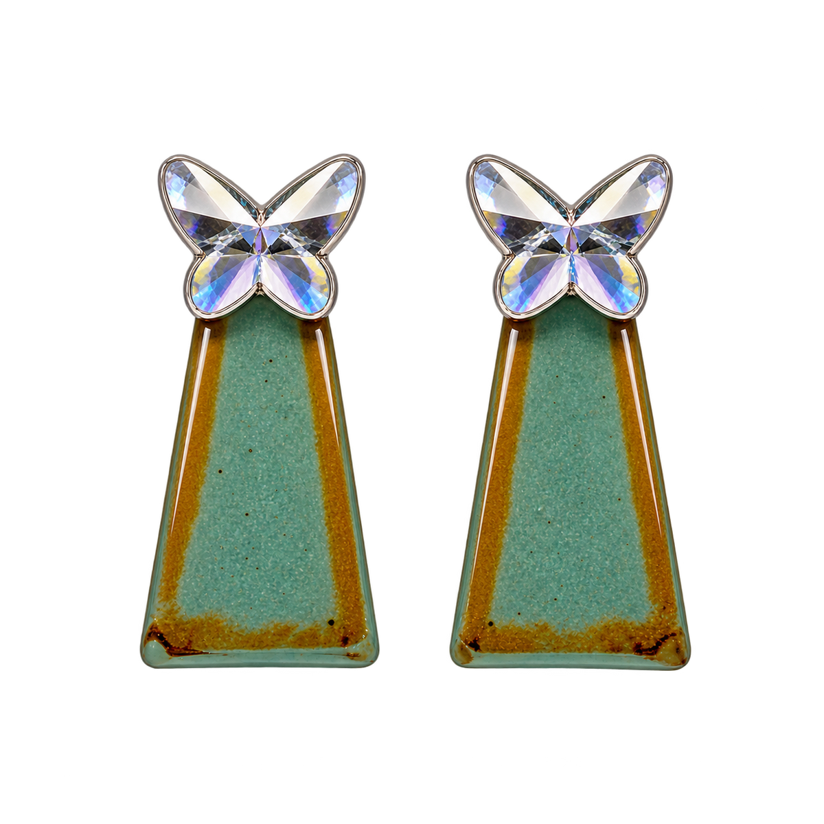 a faceted silver-colored butterfly with a teal-green geometric drop accented with warm golden tones