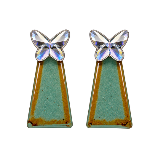 a faceted silver-colored butterfly with a teal-green geometric drop accented with warm golden tones
