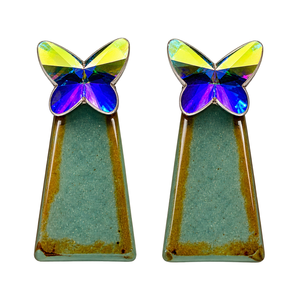 a faceted silver-colored butterfly catching the light and reflecting back blues and yellows, with a teal-green geometric drop accented with warm golden tones